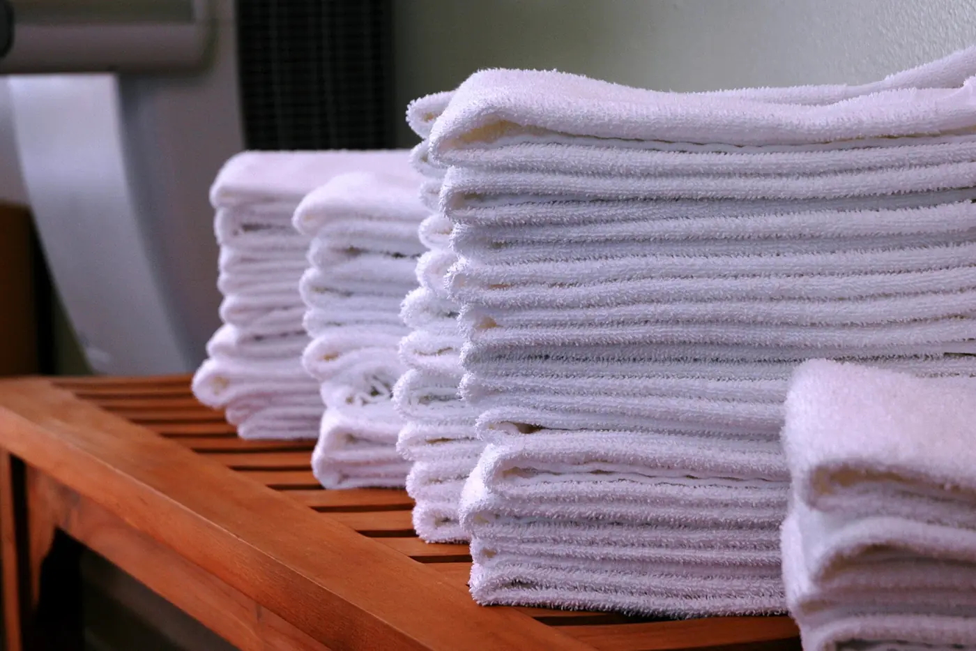 Stacks of clean gym towels on a wooden bench